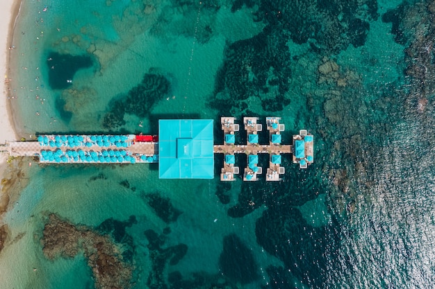 Aerial view of resort pierce in transparent sea water with rocks