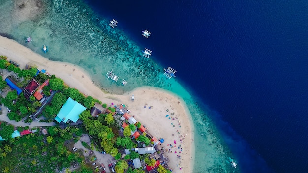 Aerial view of sandy beach with tourists swimming in beautiful clear sea water of the Sumilon island beach landing near Oslob, Cebu, Philippines. - Boost up color Processing.