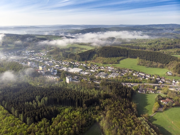 Aerial view shot of beautiful green fields and houses of the countryside on a sunny day