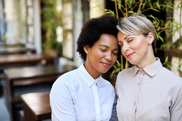 Affectionate African America woman and her female friend at outdoor cafe