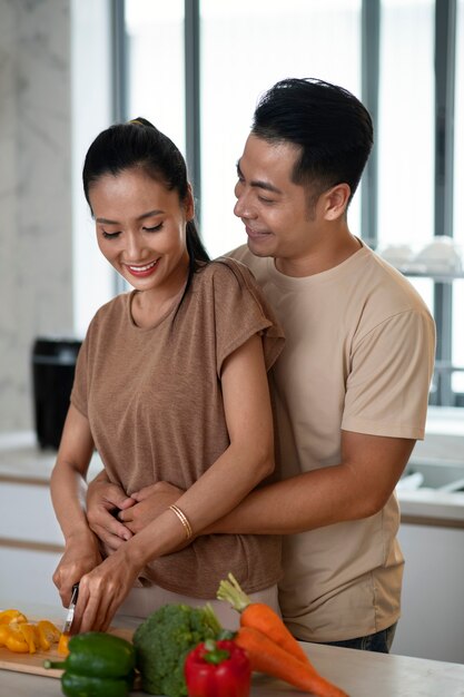 Affectionate couple cooking together vegetables in the kitchen