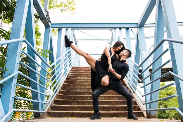 Affectionate couple dancing on bridge