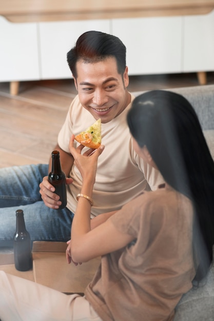 Affectionate couple at home having pizza and beer