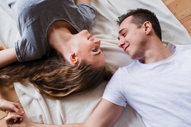 Affectionate happy couple lying on floor together