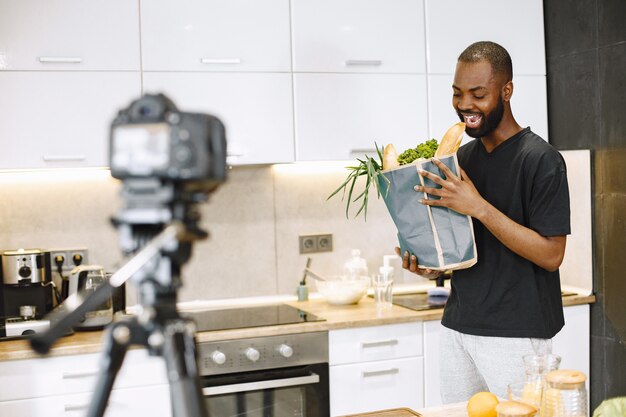 African-american bearded man smiling and holding a package with food