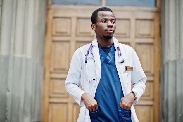 Free photo african american doctor male at lab coat with stethoscope outdoor against clinic door