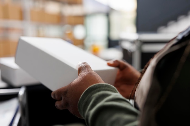 African american employee holding white cardboard boxes preparing packages for shipping in storehouse Storage room worker wearing industrial overall working at customers orders in warehouse