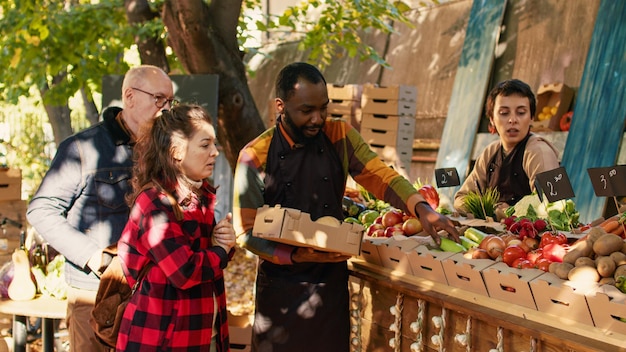 Free photo african american farmer putting fresh products in box