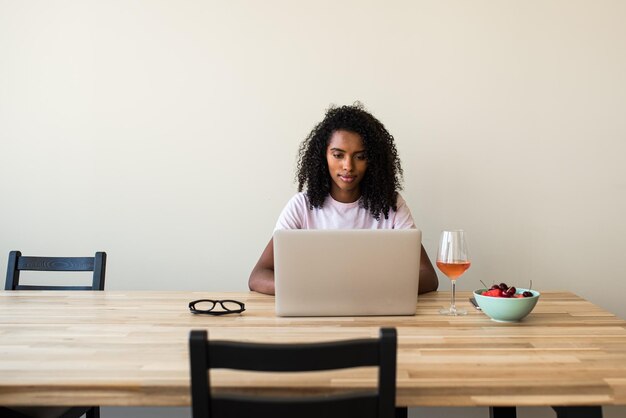 African American female freelancer using laptop at home