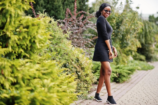 African american girl in sunglasses black clothes and shirt posed outdoor Fashionable black woman