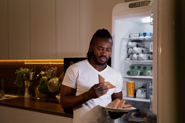 African american man eating from the fridge at night