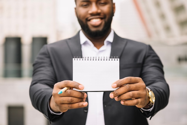 African-American man holding blank notebook