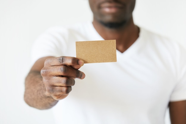 African American man holding brown empty business card