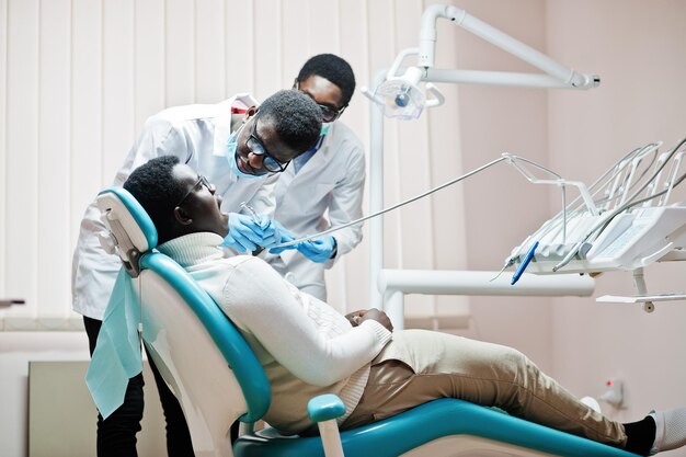 African american man patient in dental chair Dentist office and doctor practice concept Professional dentist helping his patient at dentistry medical Drilling patient's teeth in clinic