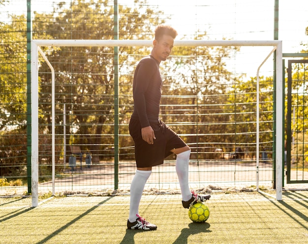 African american man playing with a soccer ball outside