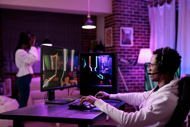 Free photo african american player streaming online video games play on pc, using computer to have fun with esport gaming tournament. male gamer playing action game championship on internet.