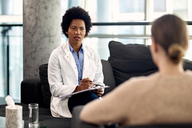 African American psychologist talking to a patient during an appointment at her office