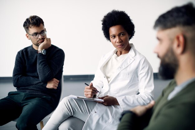 African American psychotherapist having a session with group of people