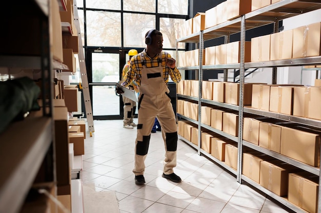 Free photo african american shipment manager dancing in warehouse aisle