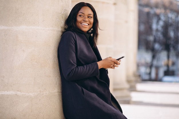 Free photo african american student girl with phone by the university