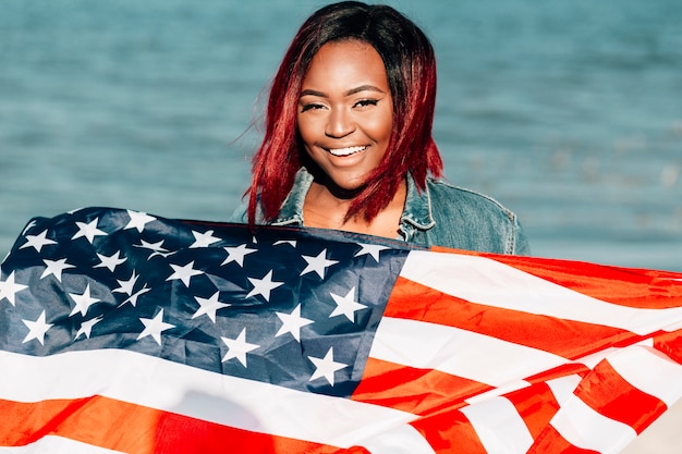 Free photo african american woman holding american flag