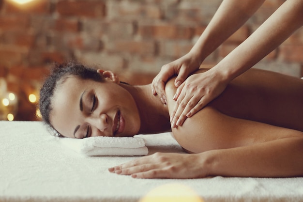 Free photo african american woman receiving a relaxing massage at the spa