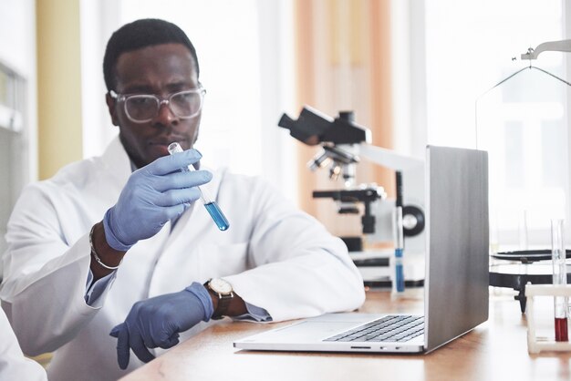 An African American worker works in a laboratory conducting experiments.