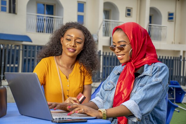 African females shopping online while sitting in a cafe