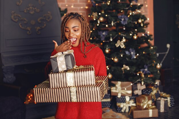 African girl in a Christmas decorations/ Woman in a red sweater. New Year concept.