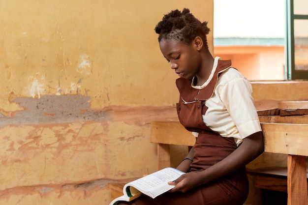 African kid leaning in class