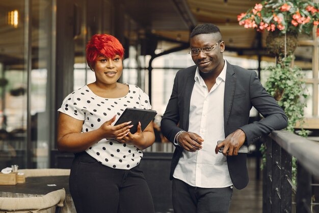 African man. Guy in a black suit. People with a tablet. Girl in white blouse.