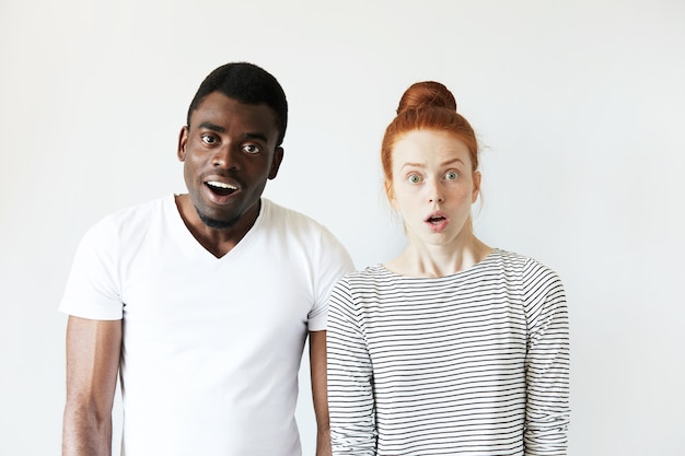 Free photo african man in white t-shirt and redhead caucasian woman in striped top