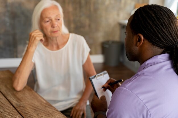 African social worker helping a senior woman