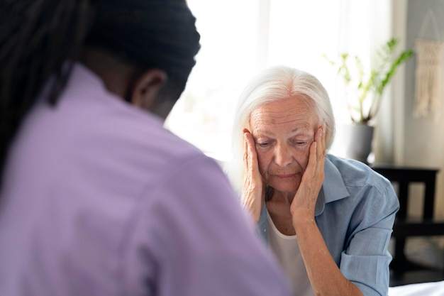 Free photo african social worker taking care of a senior woman