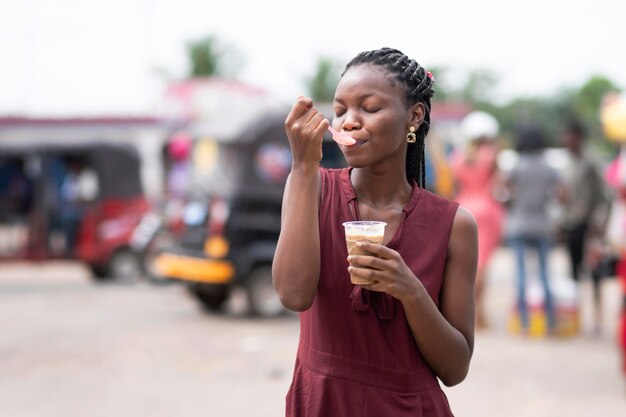 African woman eating a cold beverage