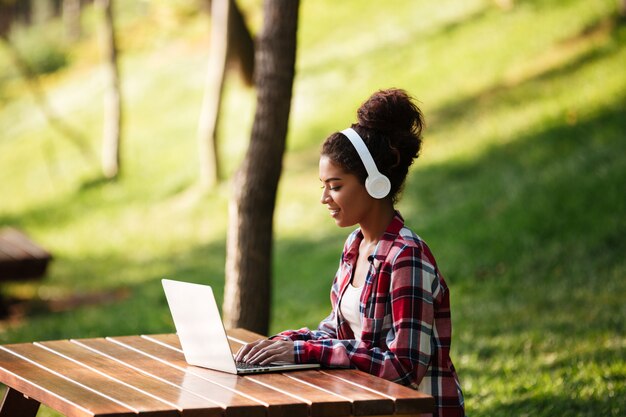 African woman sitting outdoors in park.