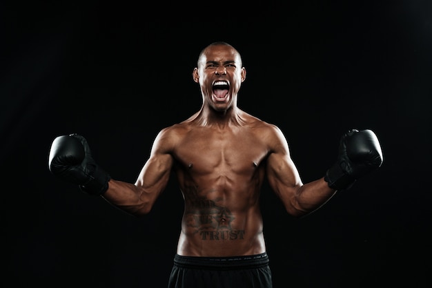 Afro american boxer celebrating his victory with raised arms