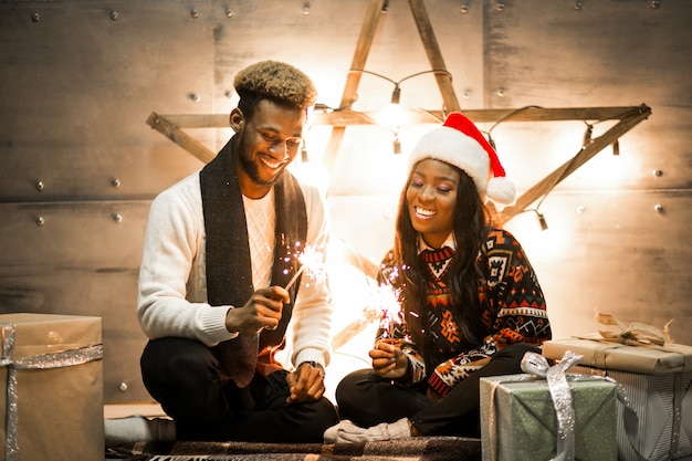 Afro american couple sitting with bengal lights