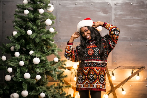 Afro american woman hanging toys on a Christmas tree