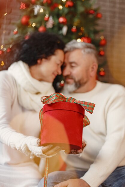 Age and people concept . Senior couple at home. Woman in a white knited sweater.