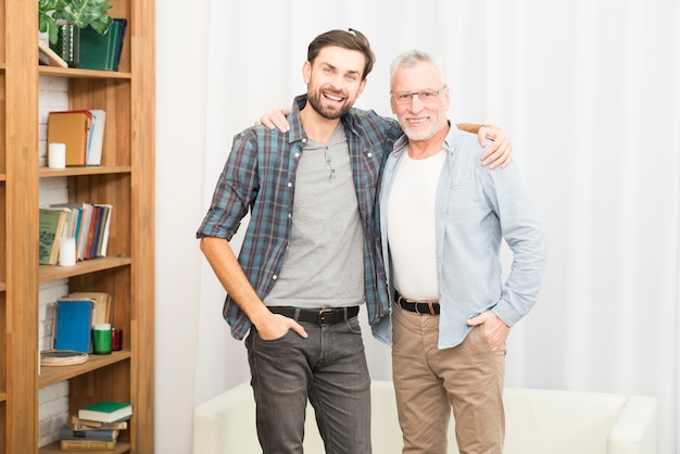 Aged man hugging with young happy guy