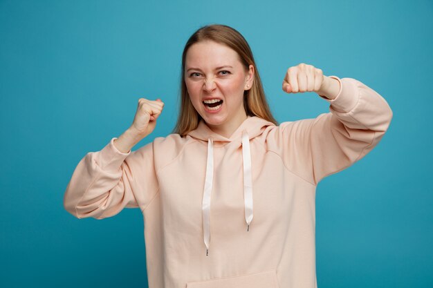 Aggressive young blonde woman doing boxing gesture 