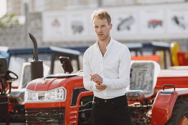 Free photo agronomist choosing a new planter. man at the outdoor ground of the shop. agricultural machinery.