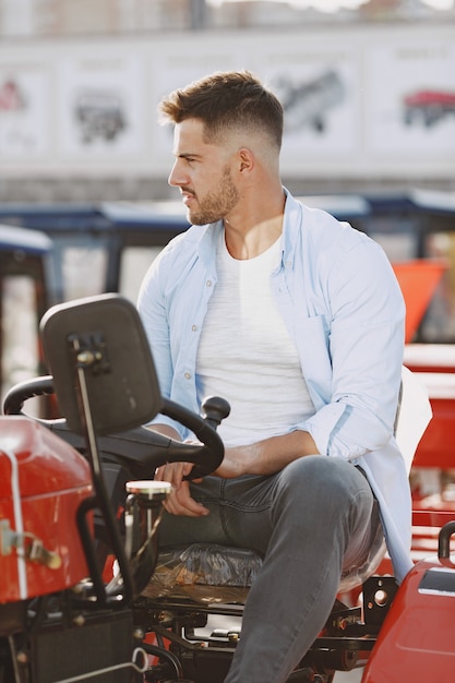 Free photo agronomist choosing a new planter. man at the outdoor ground of the shop. agricultural machinery.