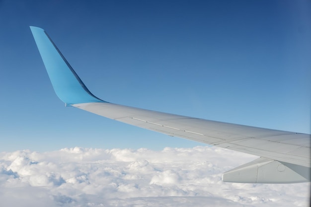 Aircraft wing view from airplane window seat Blue sky and cloud