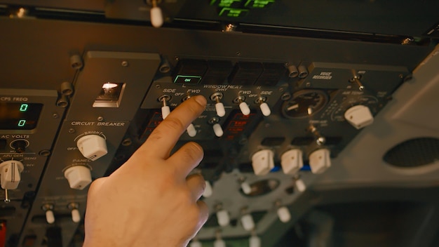 Free Photo airplane captain starting aircraft engine power buttons on control panel in pilot cabin, flying plane with dashboard command. takeoff switch and windscreen for transport. handheld shot. close up.