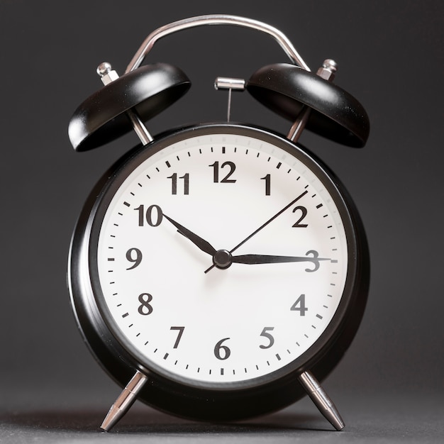 An alarm clock on black backdrop