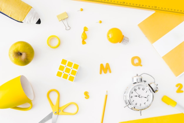 Free photo alarm clock and yellow school supplies