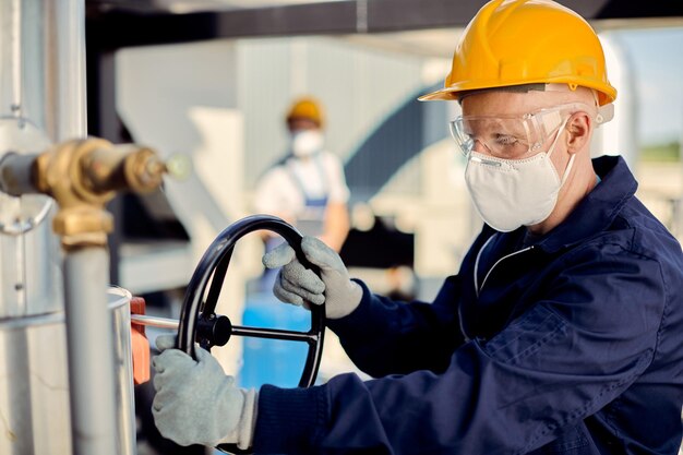 Albino worker with face mask tightening valve at construction site