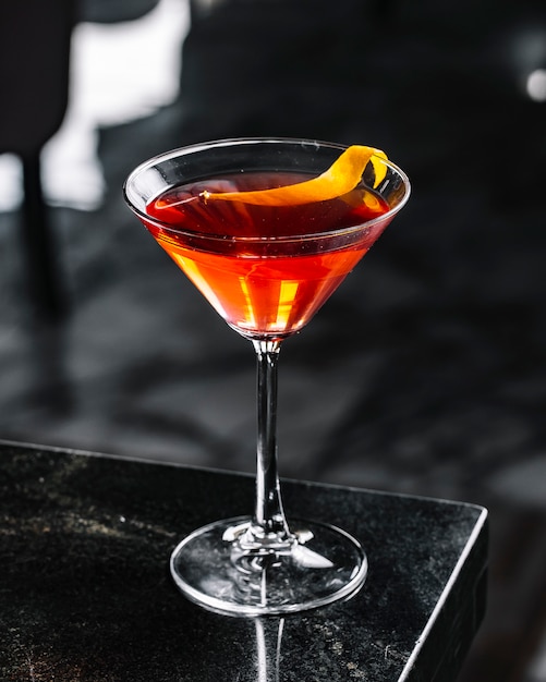 Alcohol cocktail with orange peel side view